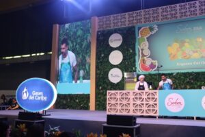 El chef Juan Diego Vanegas realiza un show de cocina en vivo en la tarima principal del evento Sabor Barranquilla. En el escenario destacan pantallas gigantes, decoración alusiva a la "Riqueza Caribe" y los logos de Sabor Barranquilla y Gases del Caribe.