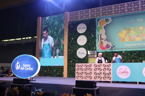 El chef Juan Diego Vanegas realiza un show de cocina en vivo en la tarima principal del evento Sabor Barranquilla. En el escenario destacan pantallas gigantes, decoración alusiva a la "Riqueza Caribe" y los logos de Sabor Barranquilla y Gases del Caribe.