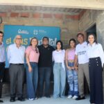 Grupo de ocho personas posa frente a un letrero que dice "el gas natural" y lleva los logotipos de Gases del Caribe y Puerto Colombia.
