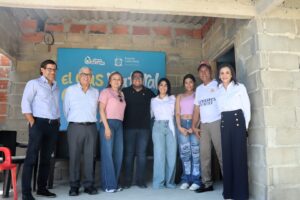 Grupo de ocho personas posa frente a un letrero que dice "el gas natural" y lleva los logotipos de Gases del Caribe y Puerto Colombia.